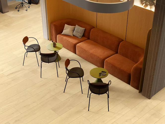 Aranżacja kawiarni, połączenie miedzianych foteli, czarnych krzeseł i paneli podłogowych wodoodpornych w kolorze Dąb Wigra