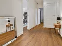 Projekt korytarza w mieszkaniu - białe drzwi i ściany skomponowane z panelami podłogowymi wodoodpornymi Sienna R170